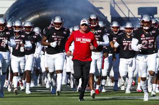 Coach Tony Sanchez runs out onto the field with the Rebels during a game against San Jose Spartans at Sam Boyd Stadium, Saturday, Nov. 23, 2019.