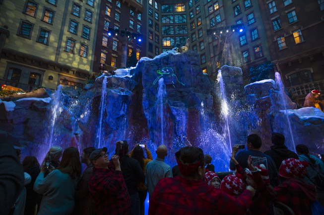Guests watch a holiday-inspired laser light show during a tree ...