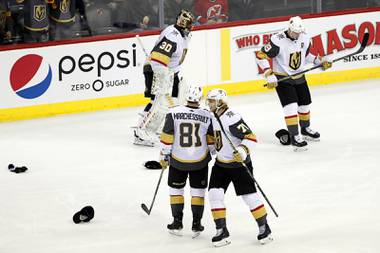 Golden Knights center William Karlsson (71) congratulates center Jonathan Marchessault (81) as goaltender Malcolm Subban (30) and right wing Reilly Smith (19) try to avoid skating over hats thrown onto the ice after Marchessault scored the third of his three goals during the third period of an NHL hockey game against the New Jersey Devils, Tuesday, Dec. 3, 2019, in Newark, N.J. The Golden Knights defeated the Devils 4-3. 