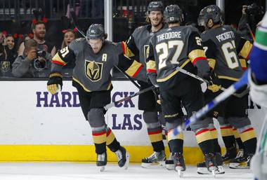 Vegas Golden Knights right wing Mark Stone, left, celebrates after scoring against the Vancouver Canucks during the second period of an NHL hockey game Sunday, Dec. 15, 2019, in Las Vegas. 
