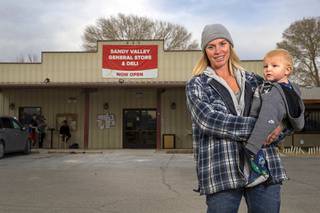 Jasmyn Fletcher poses with her son Dakota, 11 months, in front of the Sandy Valley General Store on Wednesday, Dec. 18, 2019. She and her husband, Derrick, own the store.