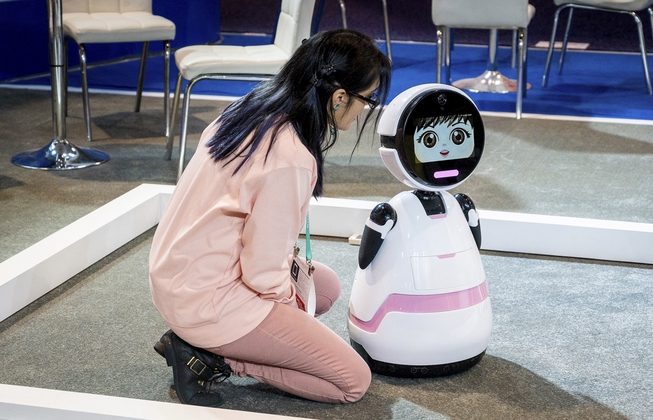 A booth attendant interacts with a robot in the Chuangze ...