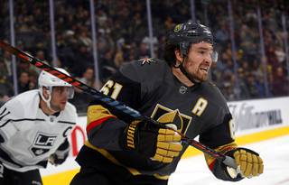 Vegas Golden Knights right wing Mark Stone (61) is followed by Los Angeles Kings center Anze Kopitar (11) as they chase after the puck in the third period at T-Mobile Arena Thursday, Jan. 9, 2020.