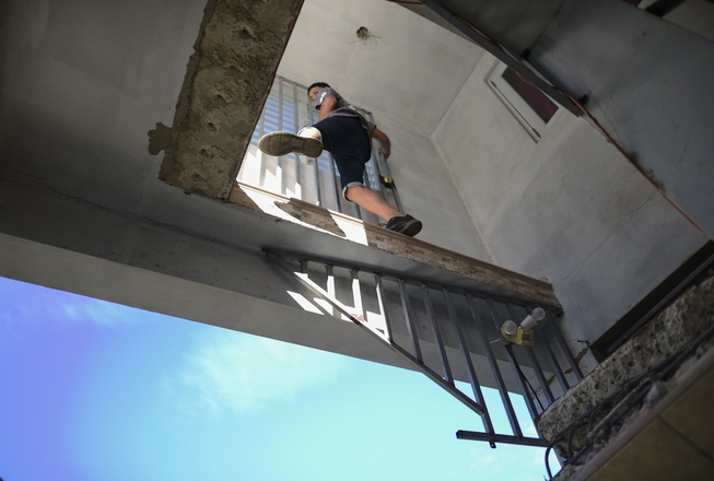 A youth climbs into his aunt's damaged home where the ...
