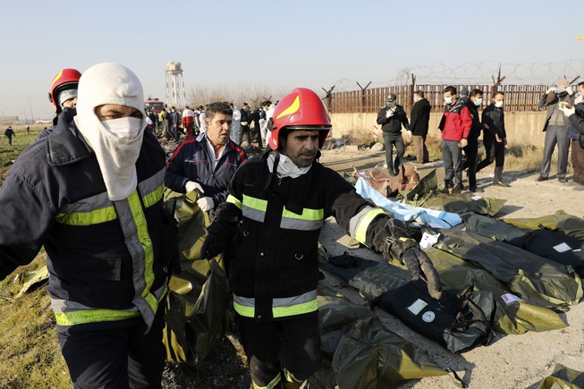 Rescue workers carry the body of a victim of an ...