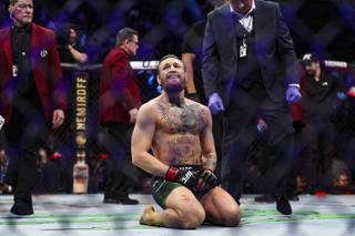 Conor McGregor kneels in the octagon after he knocks out Donald 
