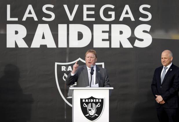 Las Vegas Raiders owner Mark Davis, center, speaks during a news conference, officially renaming the Oakland Raiders to the Las Vegas Raiders, in front of Allegiant Stadium Wednesday, Jan. 22, 2020. Raiders president Marc Badain listens at right.