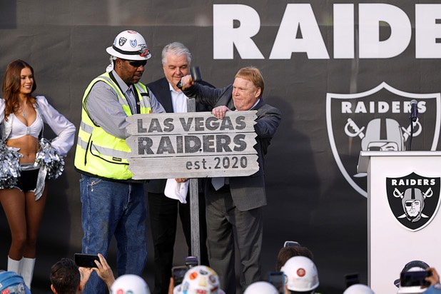 Las Vegas Raiders owner Mark Davis participates in a "staking a claim" ceremony during a news conference, officially renaming the Oakland Raiders to the Las Vegas Raiders, in front of Allegiant Stadium Wednesday, Jan. 22, 2020. Nevada Governor Steve Sisolak looks on at center.