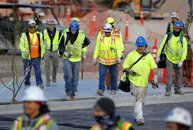 Construction workers head to a news conference, officially renaming the Oakland Raiders to the Las Vegas Raiders, in front of Allegiant Stadium in Las Vegas Wednesday, Jan. 22, 2020.