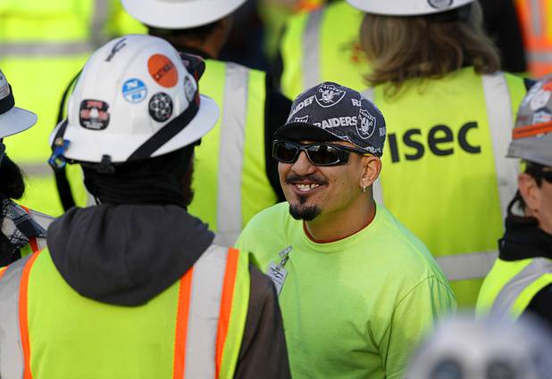 Construction workers wait for the start of a news conference, officially renaming the Oakland Raiders to the Las Vegas Raiders, in front of Allegiant Stadium in Las Vegas Wednesday, Jan. 22, 2020.
