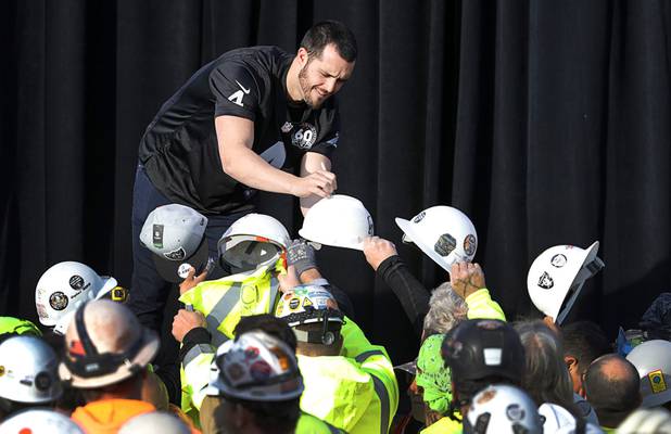 Las Vegas Raiders quarterback Derek Carr signs hard hats for construction workers during a news conference, officially renaming the Oakland Raiders to the Las Vegas Raiders, in front of Allegiant Stadium in Las Vegas Wednesday, Jan. 22, 2020.