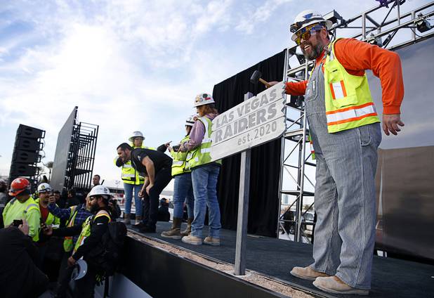 Electrician Scott Burns, IBEW Local 1, of St. Louis, poses by a Las Vegas Raiders sign during a news conference, officially renaming the Oakland Raiders to the Las Vegas Raiders, in front of Allegiant Stadium in Las Vegas Wednesday, Jan. 22, 2020.