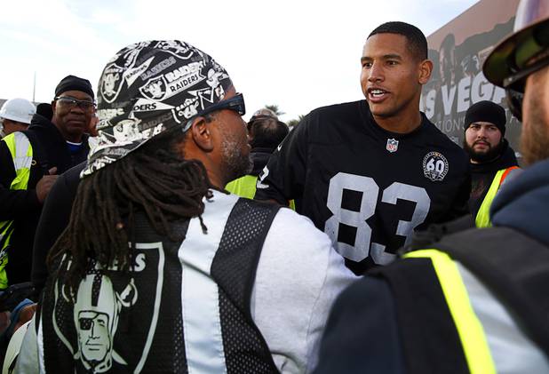 Tight end Darren Waller talks with a construction worker in Raiders garb during a news conference to officially rename the Oakland Raiders to the Las Vegas Raiders, in front of Allegiant Stadium, Wednesday, Jan. 22, 2020.