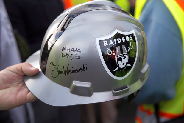 A man collects Raiders autographs on a helmet during a news conference, officially renaming the Oakland Raiders to the Las Vegas Raiders, in front of Allegiant Stadium in Las Vegas Wednesday, Jan. 22, 2020.