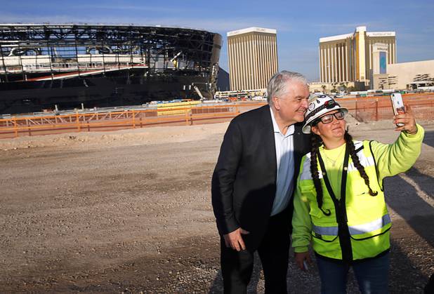 Nevada Governor Steve Sisolak poses for a photo with a construction worker during a news conference, officially renaming the Oakland Raiders to the Las Vegas Raiders, in front of Allegiant Stadium in Las Vegas Wednesday, Jan. 22, 2020.
