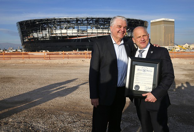 Nevada Governor Steve Sisolak, left, and Las Vegas Raider president Marc Badain pose for a photo during a news conference, officially renaming the Oakland Raiders to the Las Vegas Raiders, in front of Allegiant Stadium in Las Vegas Wednesday, Jan. 22, 2020.