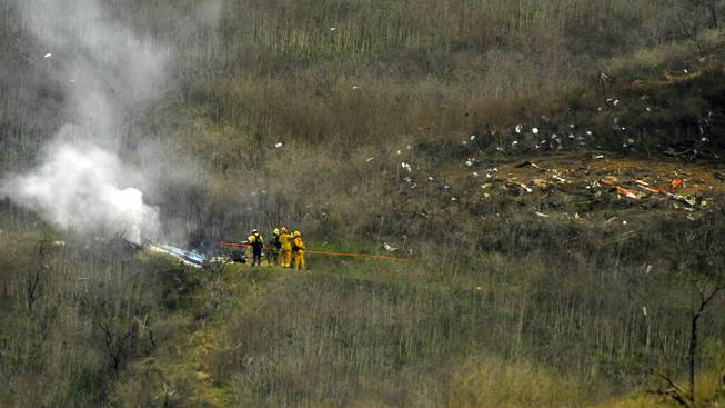 Firefighters work the scene of a helicopter crash where former NBA star Kobe Bryant died, Sunday, Jan. 26, 2020, in Calabasas, Calif. 

