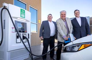 Nevada Governor Steve Sisolak  center, Mendis Cooper, left, Overton Power District #5 general manager, and Doug Cannon, president/CEO of NV Energy, pose by electric vehicle charging stations at the Eagle's Landing Travel Plaza in Mesquite, Nev. Wednesday, Jan. 29, 2020. With the new charging stations, Interstate 15 though Nevada became the Intermountain's West's first electric vehicle interstate corridor.