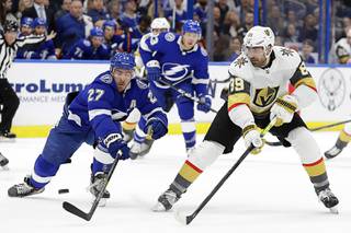 Vegas Golden Knights right wing Alex Tuch (89) flips the puck past Tampa Bay Lightning defenseman Ryan McDonagh (27) during the first period of an NHL hockey game Tuesday, Feb. 4, 2020, in Tampa, Fla.