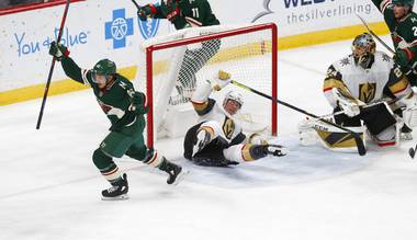 Minnesota Wild’s Jared Spurgeon, left, celebrates his power play goal off Vegas Golden Knights’ goalie Marc-Andre Fleury, right, in the first period of an NHL hockey game Tuesday, Feb. 11, 2020, in St. Paul, Minn. Landing in the net is Golden Knights’ Nick Holden.