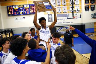 Desert Pines players, including Semaj Threats (with trophy) celebrate their 74-55 victory over Faith Lutheran to win the Class 4A Mountain Region championship at Desert Pines High School Thursday, Feb. 20, 2020.
