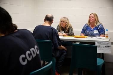 Administrators with the Nevada Department of Motor Vehicles help an inmate receive an identification card during a transitioning event at the Clark County Detention Center, Feb. 26, 2020. 