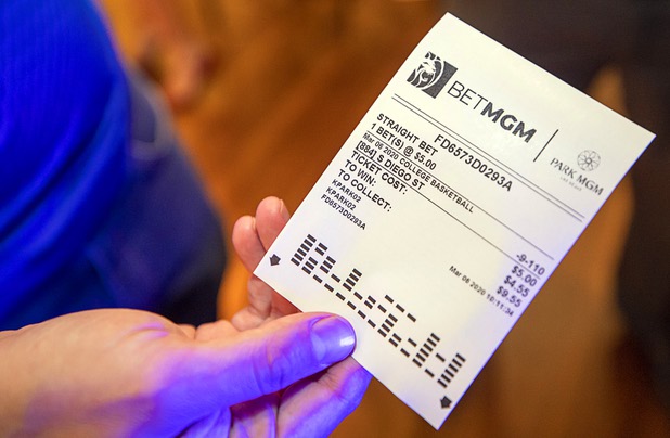 A journalist displays a betting slip on college basketball after using a self-service betting kiosk in the BetMGM sports book at the Park MGM Friday, March 6, 2020.