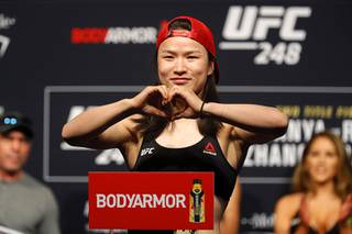 UFC women's strawweight champion Weili Zhang of China poses on the scale during a ceremonial weigh-in for UFC 248 at T-Mobile Arena in Las Vegas Friday, March 6, 2020. Zhang will defend her title against former champion Joanna Jedrzejczyk at the arena on Saturday, March 7. (AP Photo/Las Vegas Sun/)