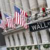 In this Jan. 3, 2020, photo, the Wall St. street sign is framed by American flags flying outside the New York Stock Exchange in New York.