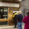 Customers wait to order at the Pizza Rock pickup window during a statewide mandated coronavirus closure of nonessential businesses Wednesday, March 18, 2020.  Nevada Gov. Steve Sisolak ordered casinos and all other nonessential businesses in Nevada to close for 30 days to help curb the virus. 