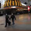 A couple walks along a usually busy Fremont Street after casinos were ordered to shut down due to the coronavirus  outbreak, Wednesday, March 18, 2020, in Las Vegas. (AP Photo/John Locher)
