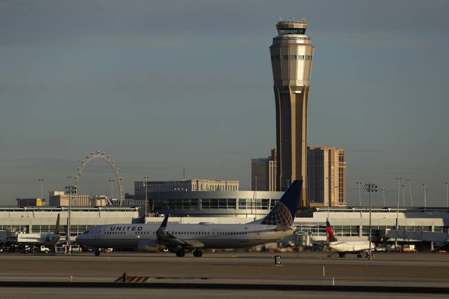 A plane takes off at McCarran International airport, Thursday, March 19, 2020, in Las Vegas.   Officials at  the airport said in a tweet that it will remain open with reduced operations after an air traffic controller tested positive late Wednesday, temporarily closing the control tower.  (AP Photo/John Locher)