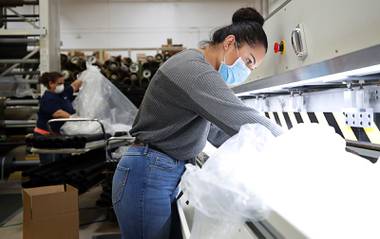 Annie Duenez “welds” the sleeves of protective gowns at the Polar Shades facility, 5520 Stephanie Street, Wednesday, March 25, 2020. The company is transitioning from manufacturing window shades to protective gowns and surgical masks to help meet demand for protective gear amid the pandemic.