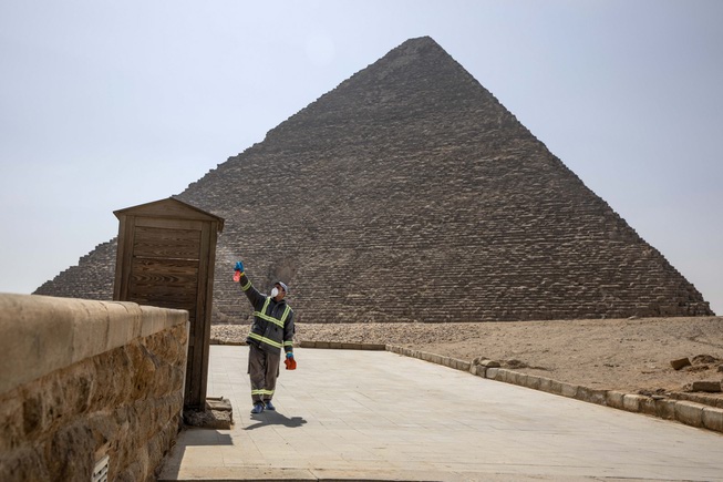 Municipal workers sanitize the areas surrounding the Giza pyramids complex ...