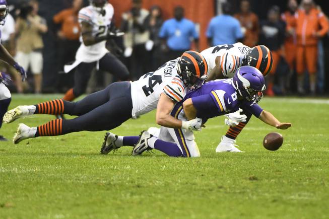 Minnesota Vikings quarterback Kirk Cousins (8) fumbles as he is sacked by Chicago Bears inside linebacker Nick Kwiatkoski, left, while Bears outside linebacker Leonard Floyd gets in on the play during the second half of an NFL football game Sunday, Sept. 29, 2019, in Chicago. The Vikings kept possession of the ball.