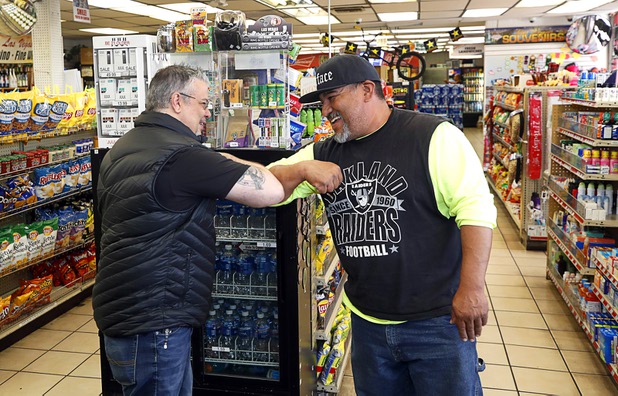 John Vizcarra, left, director of operations, elbow bumps with regular customer Eddie Quintanilla in the Stage Door Casino at Flamingo Road and Linq Lane Tuesday, March 31, 2020. The casino is closed but the market is still open.