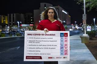 Registered nurse Nicole Koester poses for a photo with a COVID-19 checklist survey in front of MountainView Hospital in Las Vegas, Wednesday, April 1, 2020. Nurses are protesting a lack of preparedness by the nations largest hospital chain, HCA Healthcare, that they say places nurses, other staff, and patients at risk in the face of the coronavirus pandemic by not providing optimal personal protective equipment (PPE). That means N95 respirators or the more protective powered air purifying respirators (PAPRs), and other head-to-toe coverings.