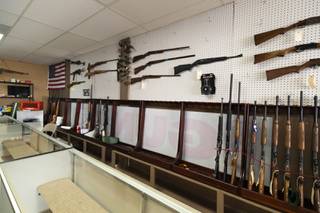 A rifle display is half empty at Elite Firearms, Monday, April 6, 2020. Joe Potter, a sales associate at the store, says he ran 475 firearm background checks in a three week period.