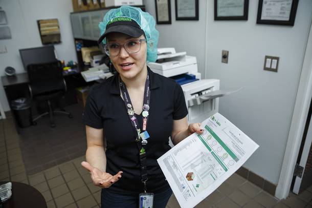 Business Development Manager Jillian Nelson shows a Certificate of Analysis during a tour of Evergreen Organix edibles production facility, Wednesday, Sept. 26, 2018.