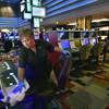 Antonia Garcia cleans slot machines at the Planet Hollywood in Las Vegas, March 18, 2020. When shuttered casinos reopen in Nevada, fewer patrons will be allowed in, nightclubs will remain closed, convention groups will be limited and gamblers will have to keep safe distances apart.