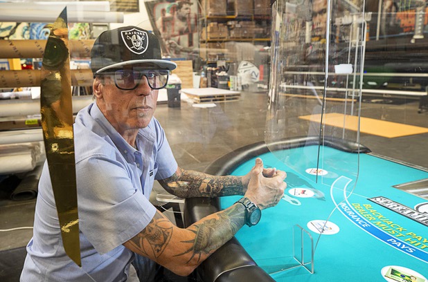 Owner James Swanson poses by a blackjack table with protective polycarbonate barriers at Screaming Images Thursday, May 7, 2020. The blackjack tables have received a lot of attention but the barriers have a variety of applications in business and office space.