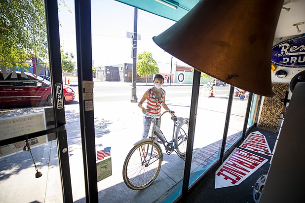 Meuy Anthony, co-owner of Vintage Vegas, brings a bicycle into the store Saturday, May 9, 2020. Saturday was the first day restaurants, salons and other nonessential businesses were allowed to reopen after restrictions were imposed to help slow the spread of the new coronavirus.