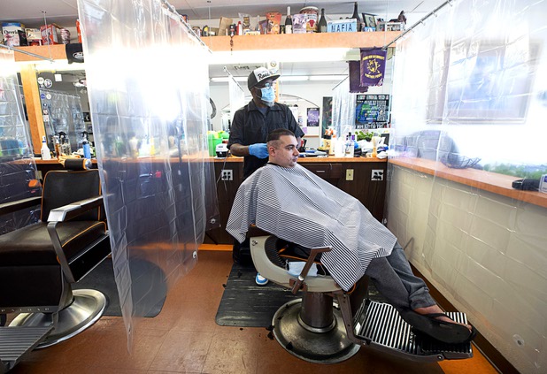 Chad Colom has his hair cut by owner Michael Jones at A Cut Above The Rest barber shop, 616 Carson Ave., Saturday, May 9, 2020. The barber shop is open for business by appointment.