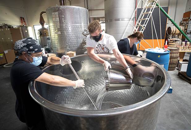 Distillery workers Julian Morales, left, and Will Wood mix hand sanitizer at the Las Vegas Distillery in Henderson Wednesday, May 13, 2020. The distillery has switched from making distilled spirits to hand sanitizer in order to help in the fight against the novel coronavirus (COVID-19).