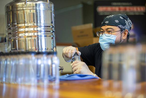 Julian Morales bottles hand sanitizer at the Las Vegas Distillery in Henderson Wednesday, May 13, 2020. The distillery has switched from making distilled spirits to hand sanitizer in order to help in the fight against the novel coronavirus (COVID-19).