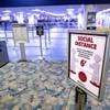 A sign reminds passengers of social distancing by a security checkpoint at McCarran International Airport Wednesday, May 20, 2020.