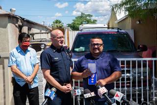 North Las Vegas Fire Chief Joseph Calhoun, along with North Las Vegas Councilman Isaac Barron, presents Jose Alvarado with a medal for his heroic actions Wed. May 20, 2020. Alvarado and another man, Vincent Torres, rescued two men from a burning house fire this past weekend.