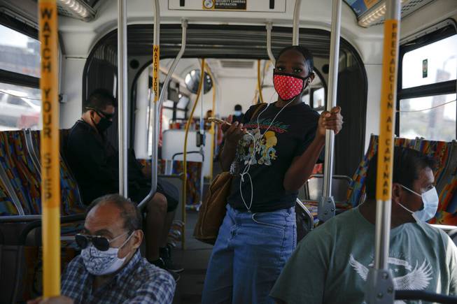 Commuters wearing masks ride a bus during the coronavirus pandemic in the Vermont Square neighborhood of Los Angeles, Thursday, May 21, 2020. While most of California took another step forward to partly reopen in time for Memorial Day weekend, Los Angeles County didn't join the party because the number of coronavirus cases has grown at a pace that leaves it unable to meet even the new, relaxed state standards for allowing additional businesses and recreational activities. 

