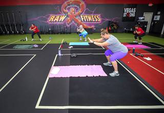 Tiffany Cox, foreground, and other members work out in social distancing squares during a session at Raw Fitness in Henderson Friday, May 29, 2020. Water parks, bars and gyms are among the business that were allowed to reopen Friday under the state's Phase Two reopening plan.