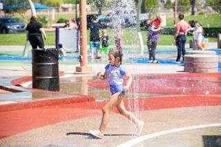 A little girl plays in the splash pad at Mission Hills Park as it re-opens to the public, Friday May 29, 2020,